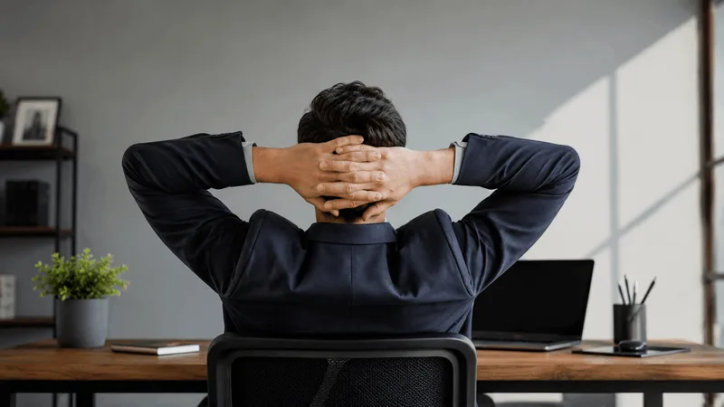 Business owner sitting back from a laptop, pausing before writing a reply to a review